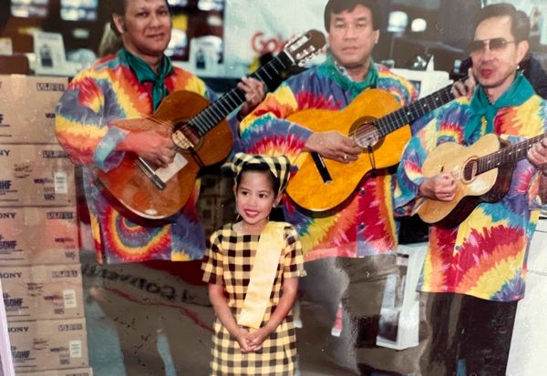Ysabel as a child with 3 adults playing guitar
